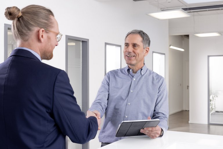 Two engineers in the foyer of TLK-Thermo GmbH Two engineers greet each other for a conversation in the foyer of TLK-Thermo GmbH