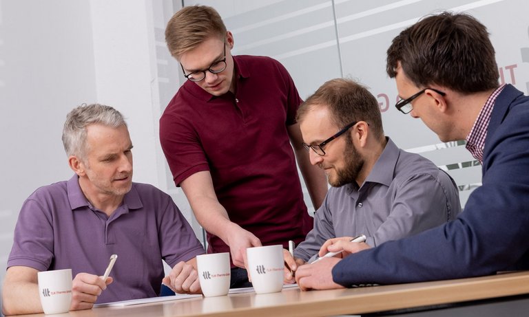 Four employees in the discussion Four employees discuss various topics in a meeting room