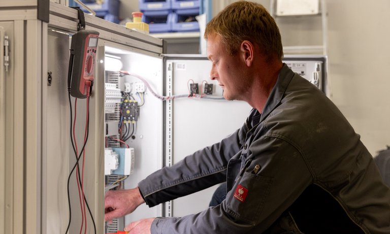 A technician sets up the switch cabinet for a test stand for measuring components with the refrigerant R290.