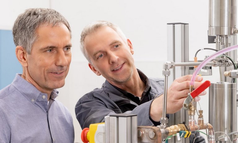 Two engineers check a test setup for measuring components with the refrigerant R744